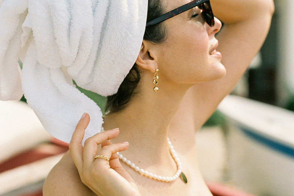 bling earrings and pearl kiss necklace model on the beach