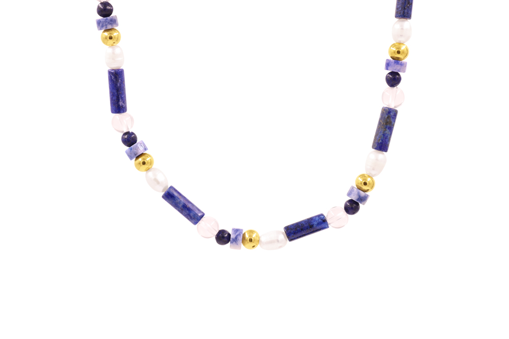 Athens Necklace with blue gemstone beads, white details, freshwater pearl, and gold-tone stainless steel accents on a light background.